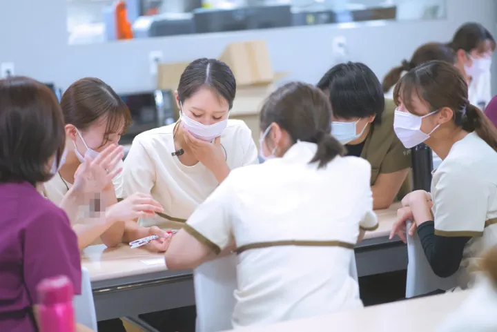 机を囲んで、話し合いながら考える歯科衛生士たち