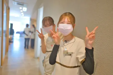 廊下でピースをする2人のスタッフ