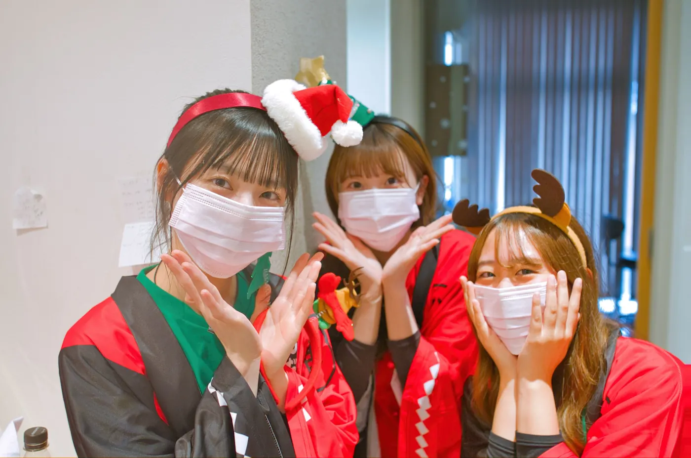 クリスマスの飾りを付けて、ポーズをとるスタッフ3人
