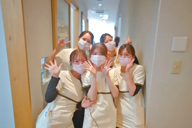 廊下で手を広げて笑うスタッフたち