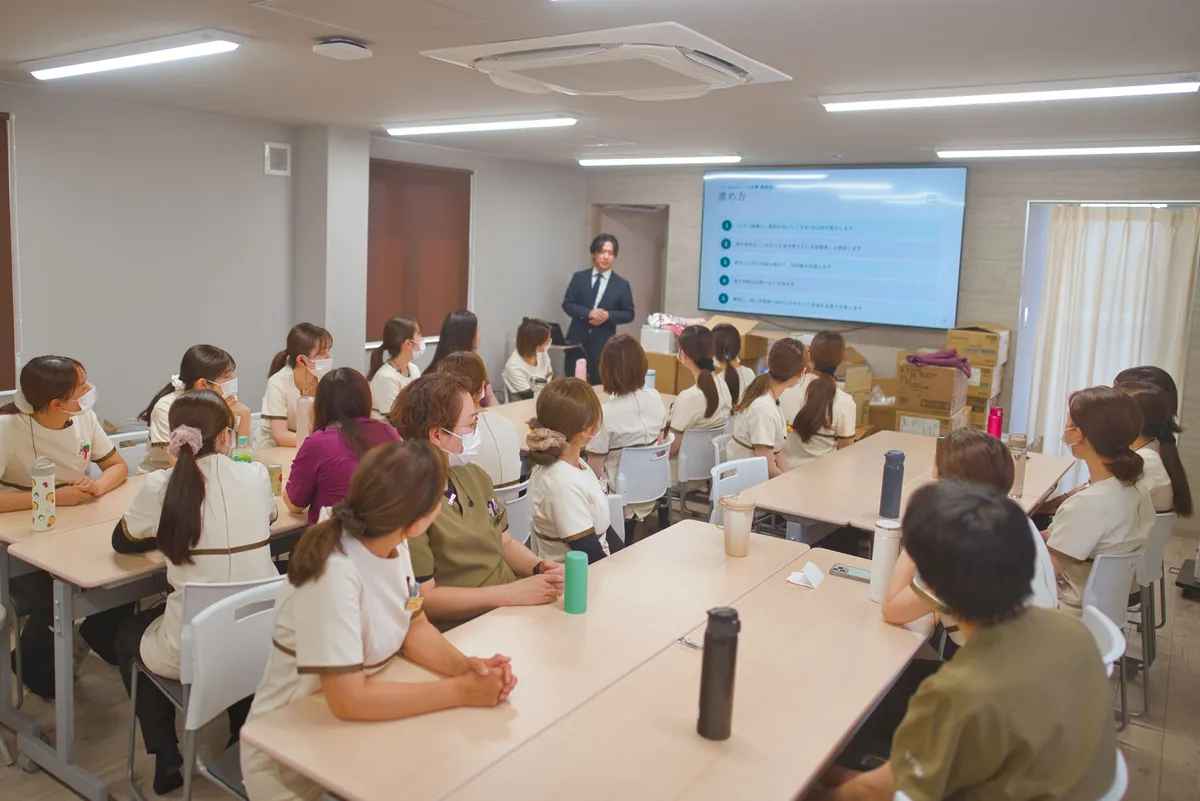 同じスタッフルームで開く院内勉強会。前のモニターに資料を映している