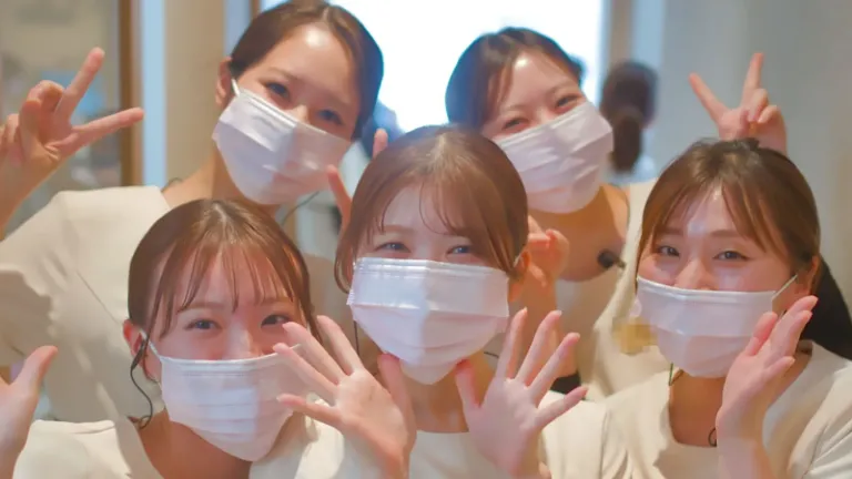 手を振って笑顔で迎える歯科衛生士たち